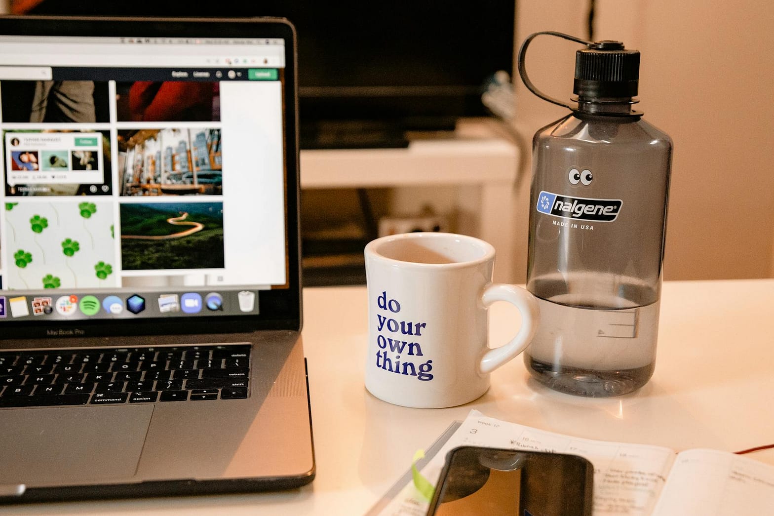 white ceramic mug beside macbook pro
