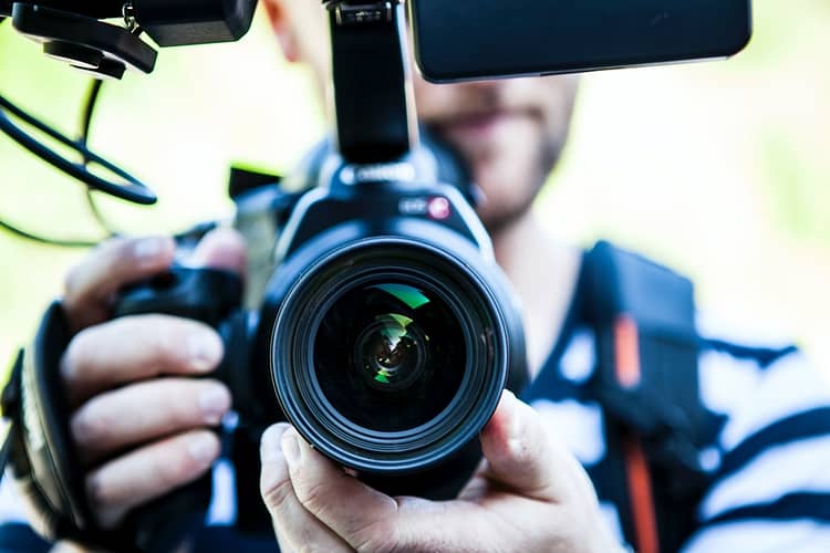 person holding canon dslr camera close up - video content creator