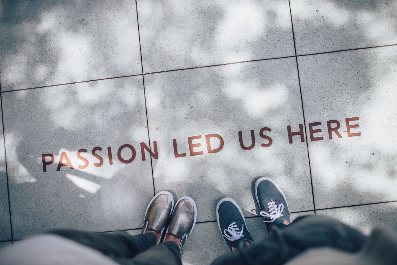 Thriving business - "passion led us here" written on floor with two people looking down.