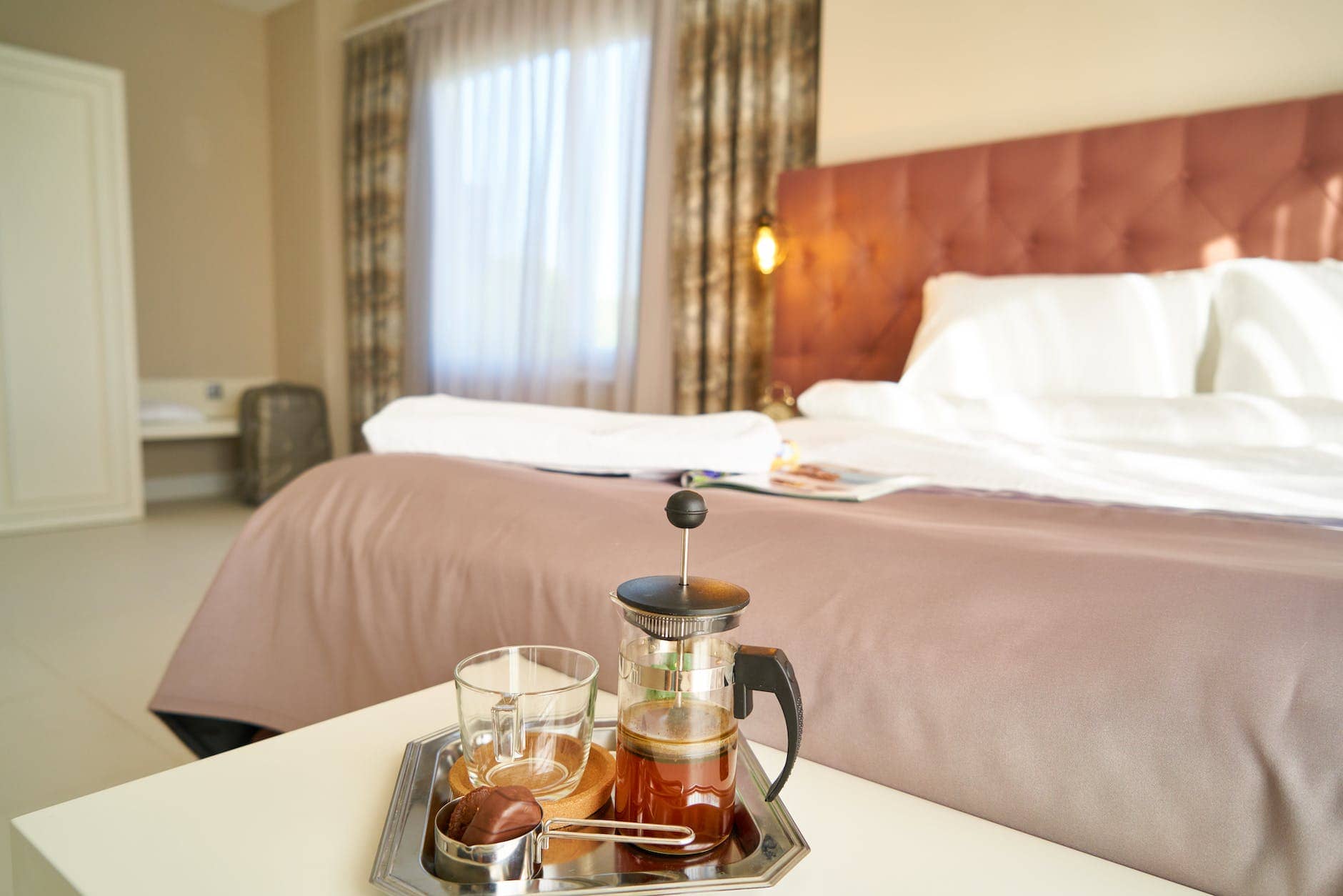 empty bed near table with tea - hotel guest experience
