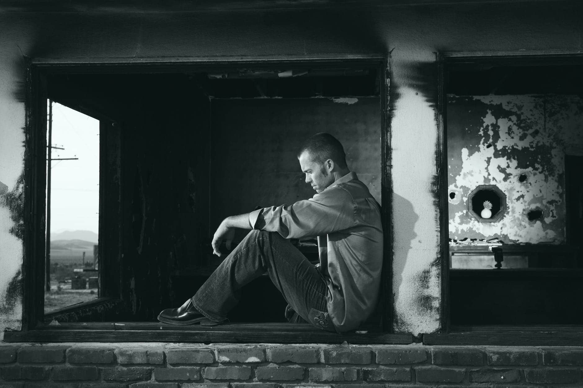 grayscale photo of man sitting - Cyclothymia vs. Dysthymia 