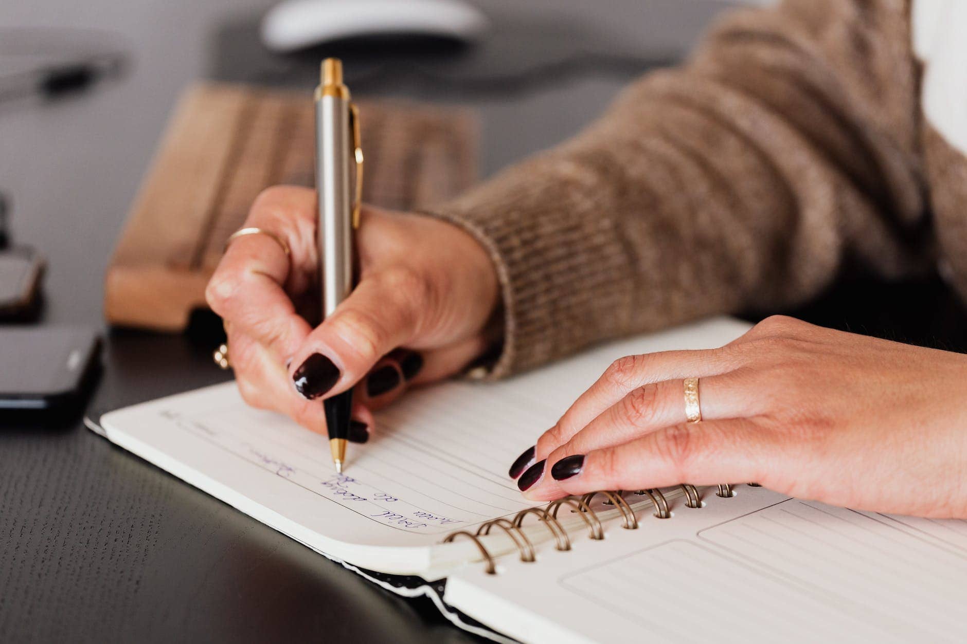 crop woman writing down notes in diary - journaling for mental health