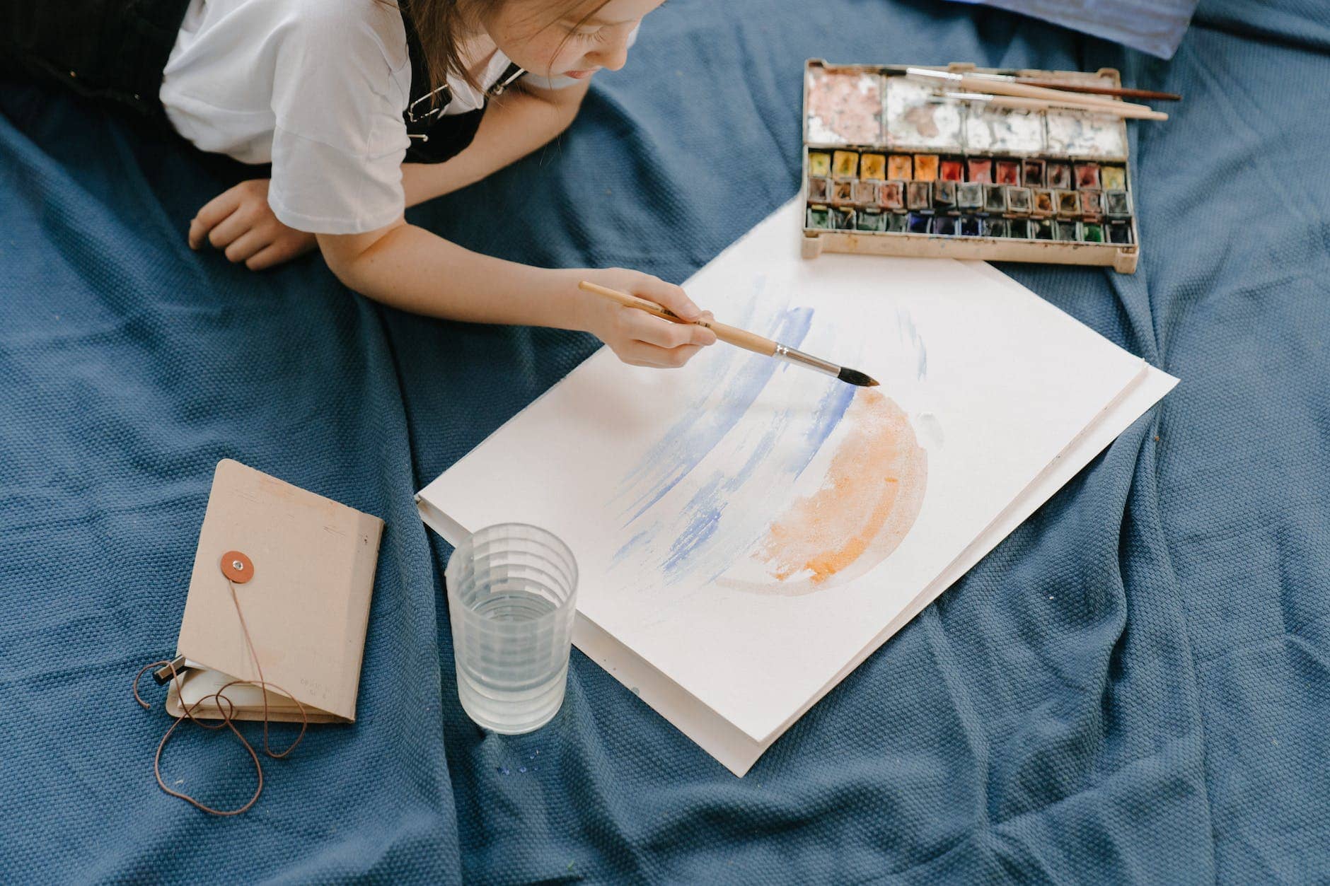 woman in white shirt holding paint brush - creative block