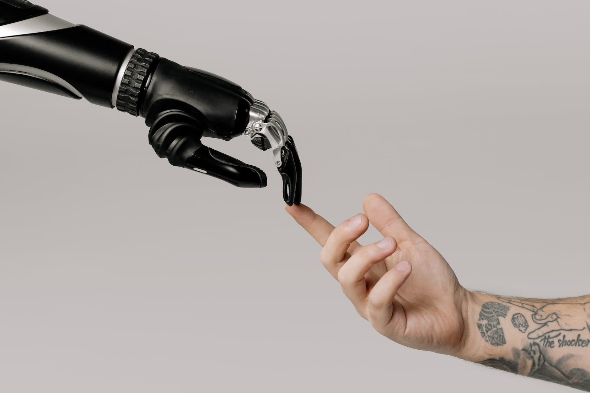 bionic hand and human hand finger pointing - The pros and cons of AI