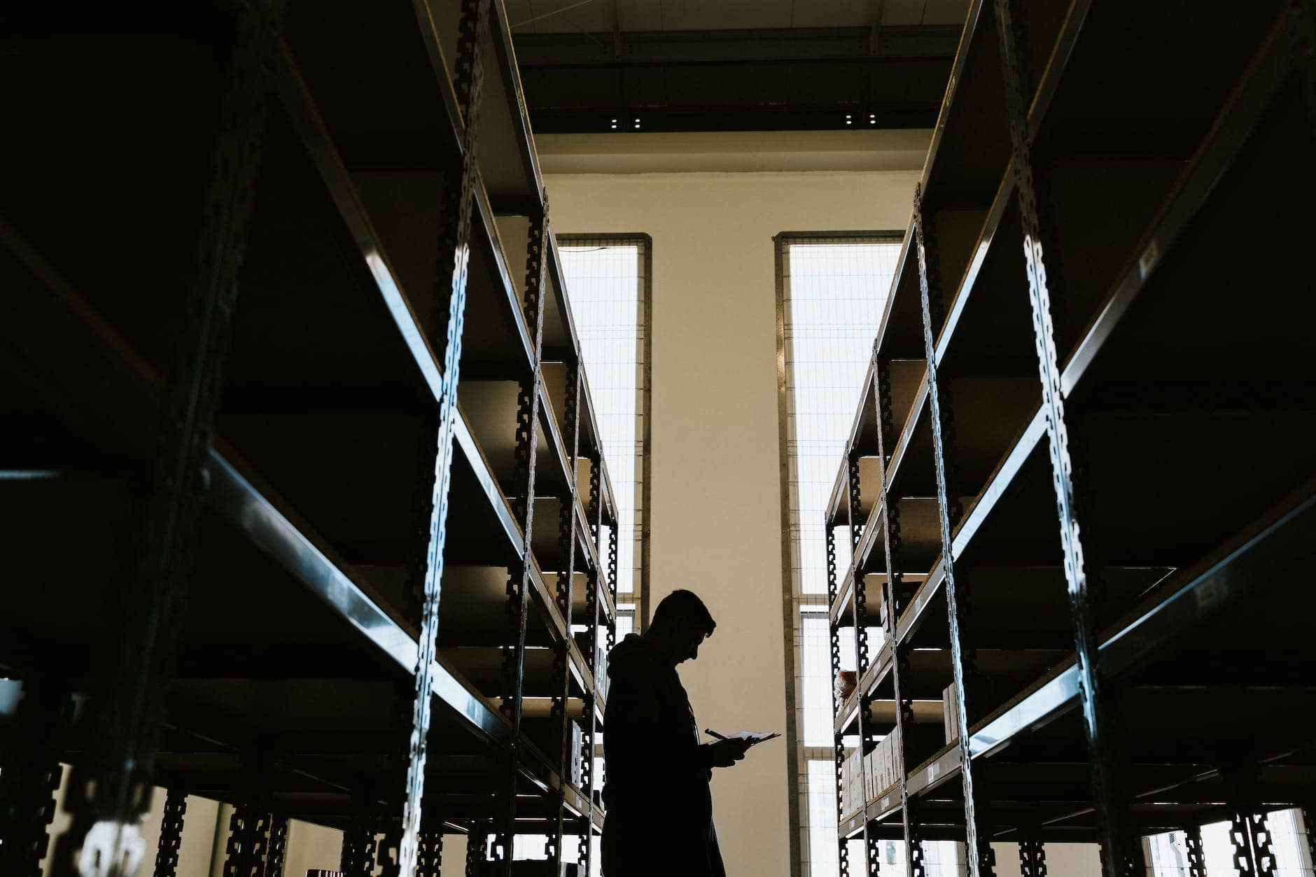 person with clipboard in warehouse - workplace lighting mistakes