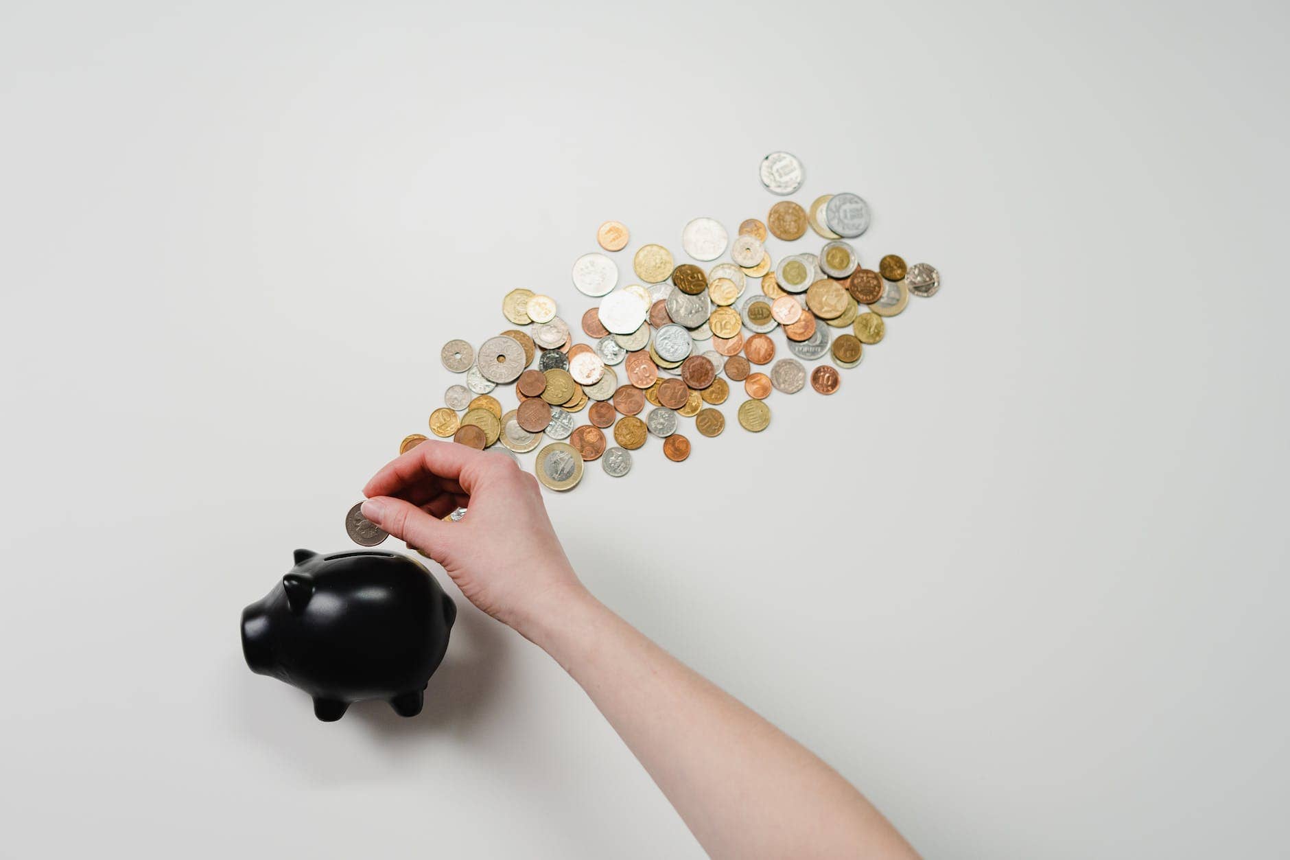 person putting coin in a piggy bank - financial health