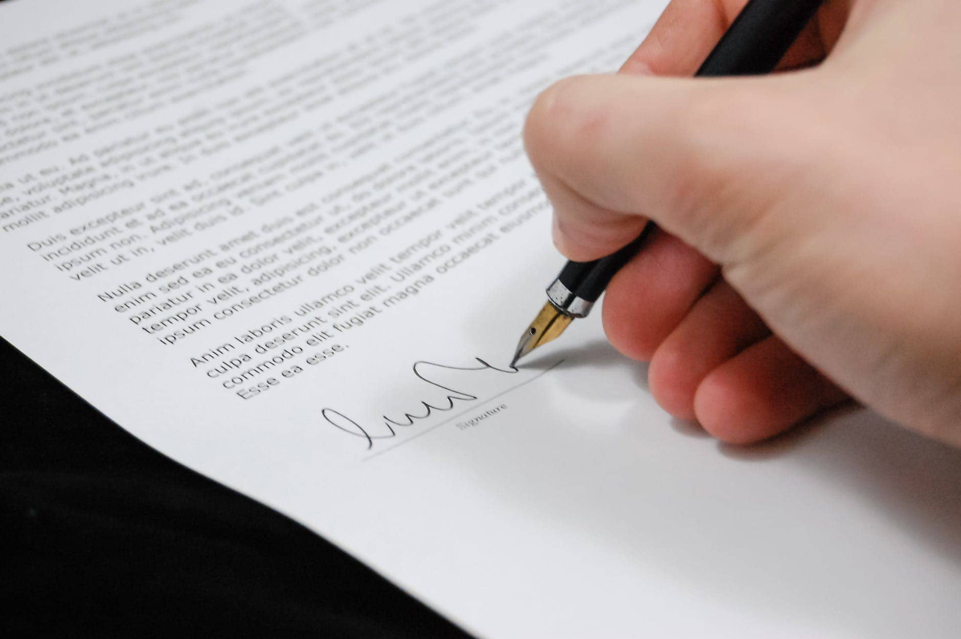 person signing in documentation paper- Protecting Your Intellectual Property