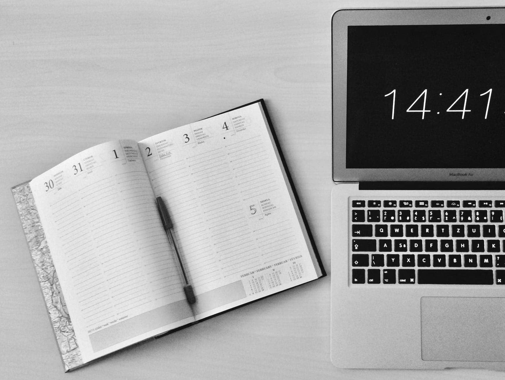 flat lay photography of unfold book beside macbook - business productivity