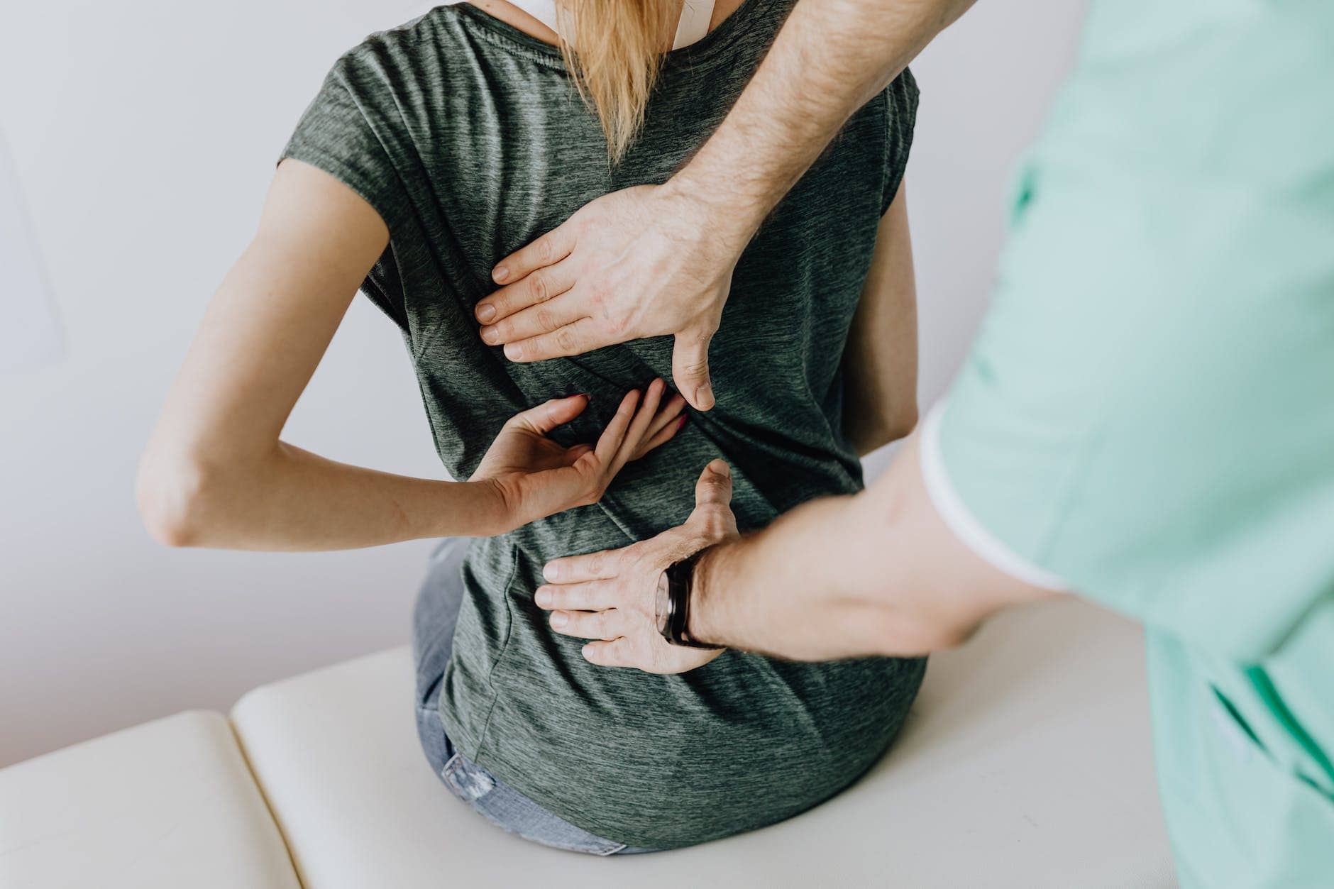 doctor examines woman s back - workplace wellness